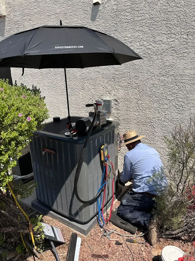 HVAC technician performing outdoor AC maintenance in Santa Paula